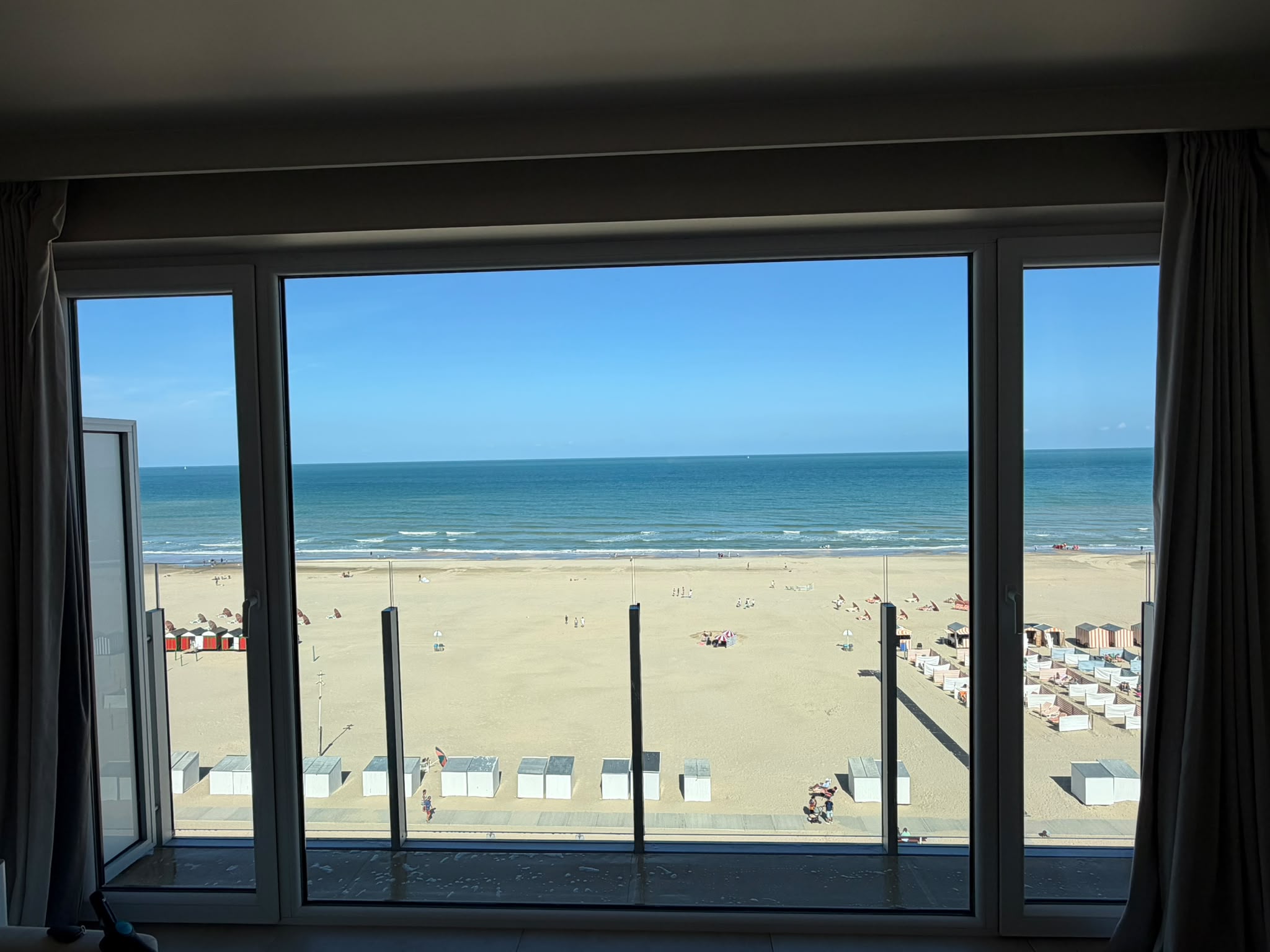 Streeploos raam van een appartement met zicht op strand en zee