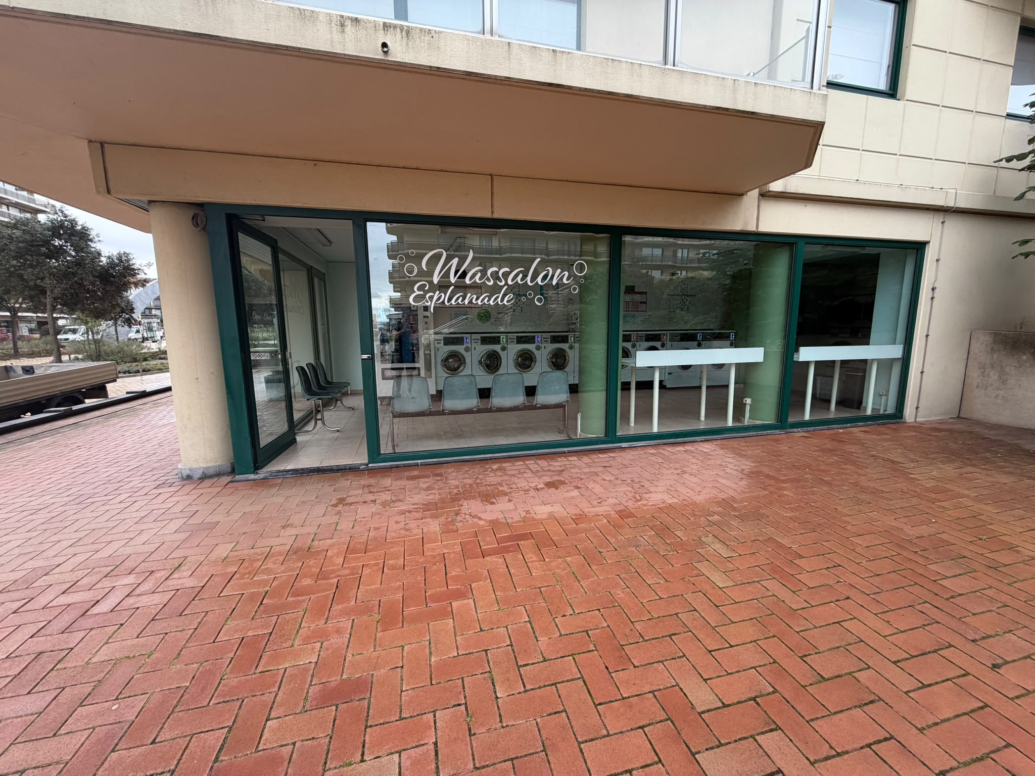 Glazen pui van Wassalon Esplanade met zicht op de wasmachines