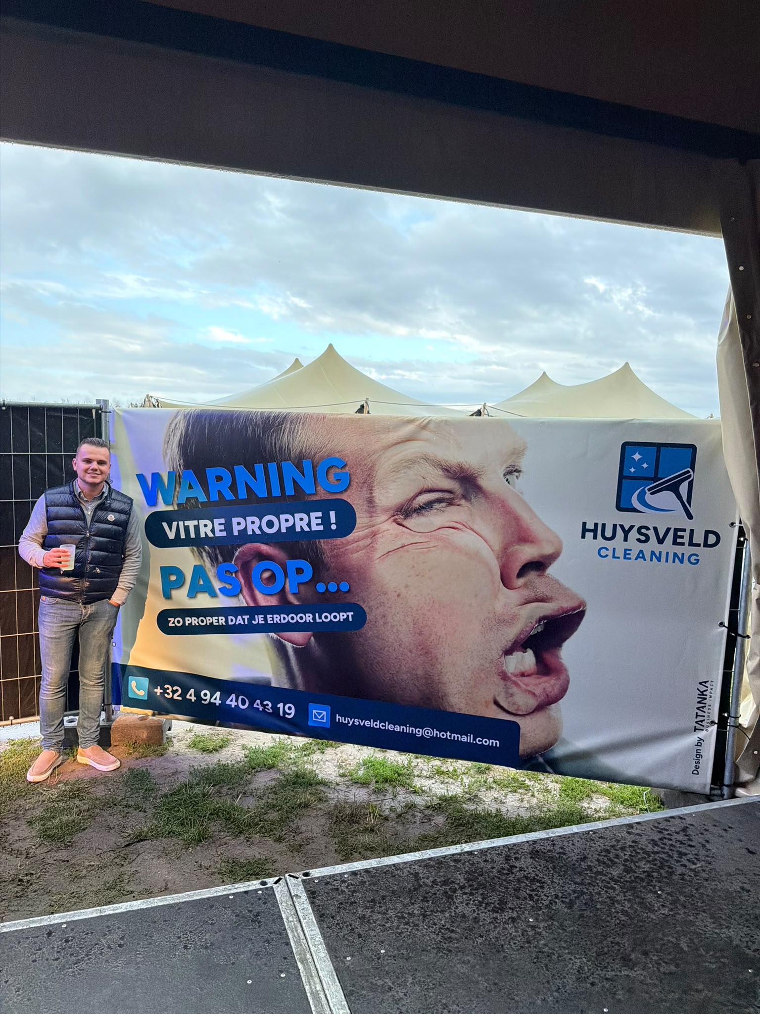 Tom naast het reclamespandoek van Huysveldcleaning