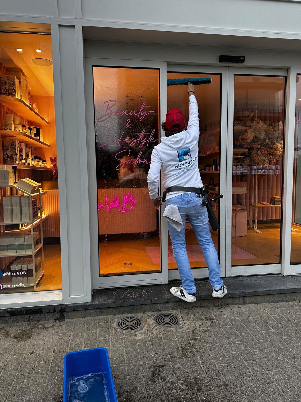 Tom reinigt de glazen schuifdeuren van een salon